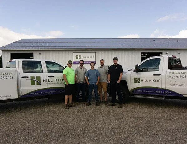 picture of Hill Hiker employees between two company vehicles