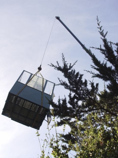 Fully enclosed incline elevator car being lifted into place by a crane in Western US