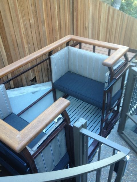 View from upper landing of a custom decorated tram lift car featuring cushioned seats and ipe hard wood railing