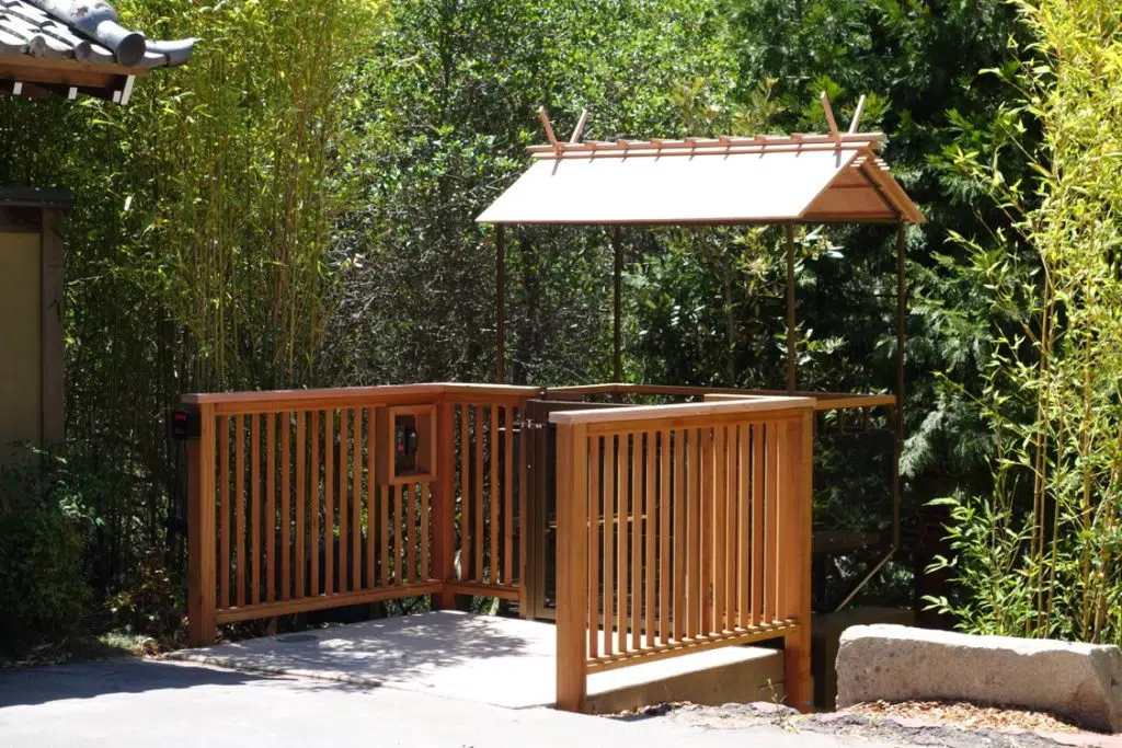 Hill lift system with wooden fence and roof in a green forest