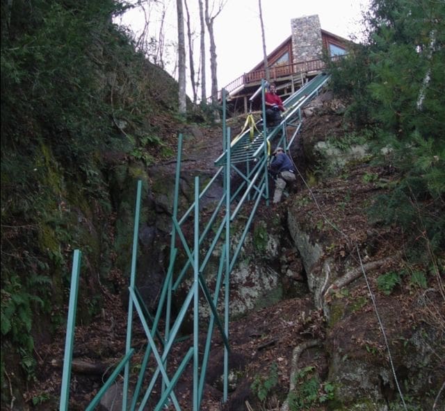 Hill Hiker installers hanging rail on a steep cliff with a hoist system for an incline cliff tram