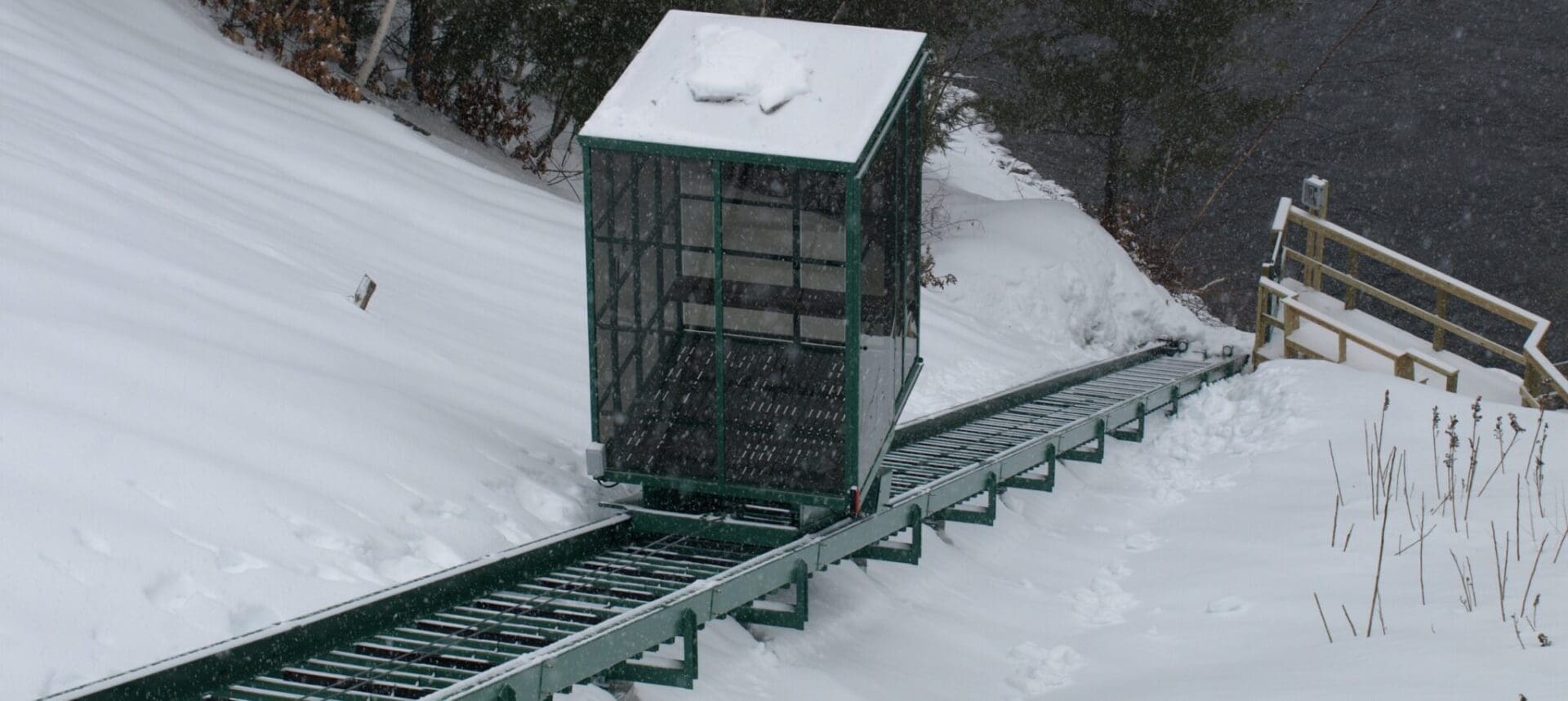 Fully enclosed Hill Hiker car travels down snowy incline railway in winter