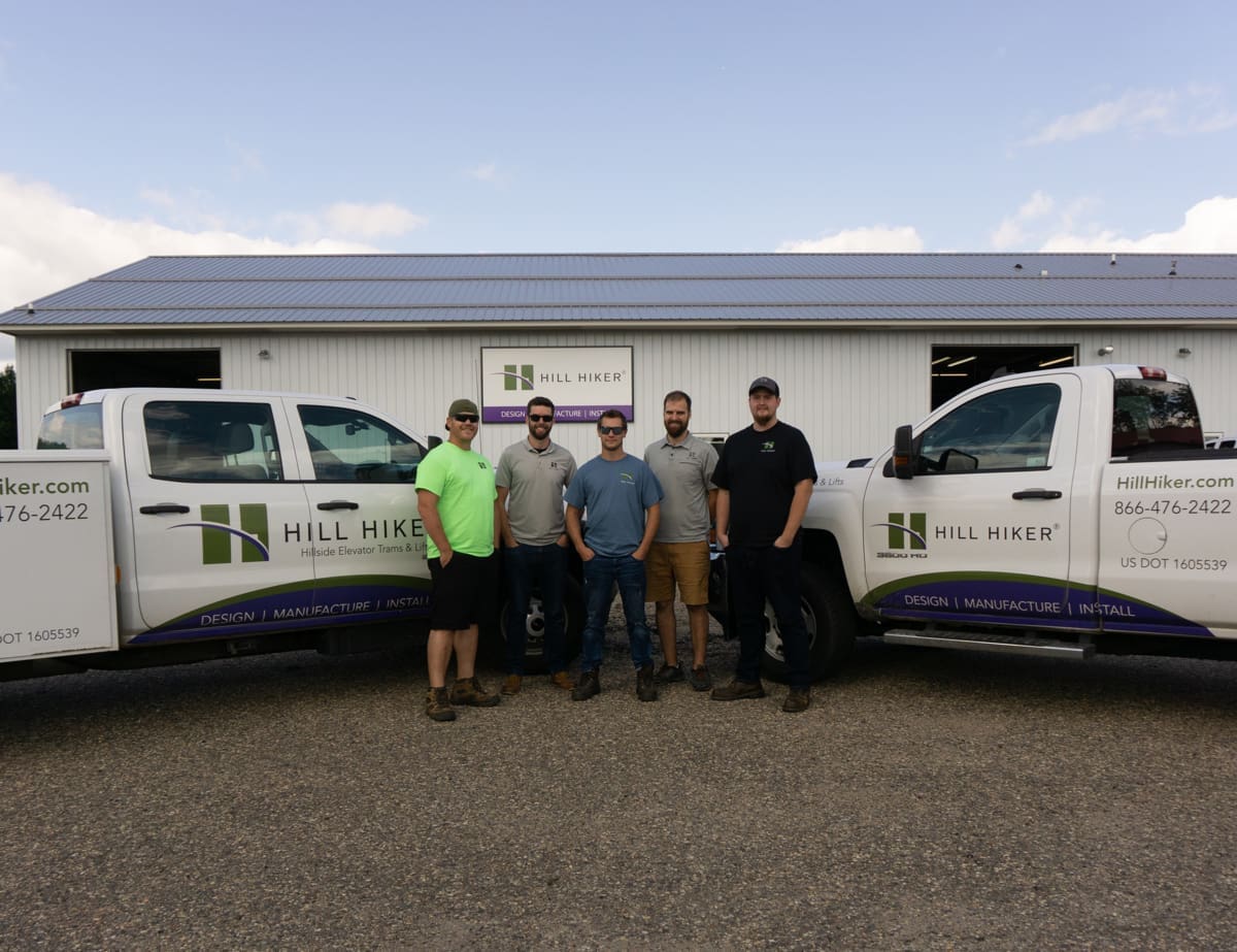 Hill Hiker lake trams and lifts install crew in front of the manufacturing facility and service trucks